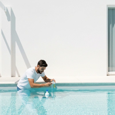 Personne vérifiant la qualité de l'eau d'une piscine avec des produits écologiques