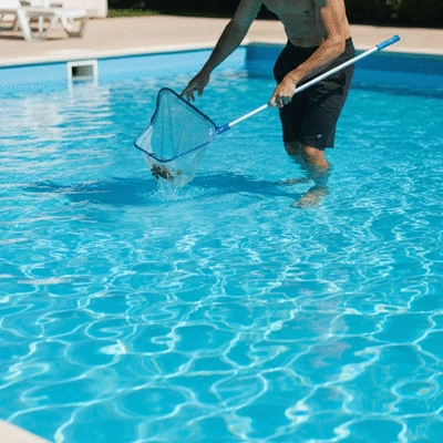 Personne nettoyant une piscine avec filet, eau bleue claire
