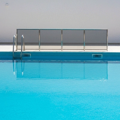 Modern swimming pool with safety barrier and clear blue water in a bright setting, no text, no words, no typography, no labels, clean image