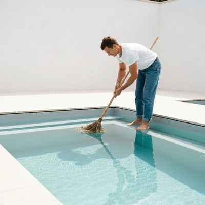 Personne nettoyant une piscine écologique avec des outils naturels