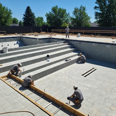 Piscine en construction avec des ouvriers travaillant sur la structure et la plomberie